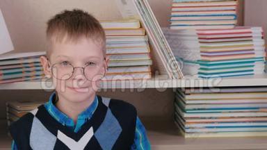 一个戴着眼镜的七岁男孩微笑着坐在书中的地板上